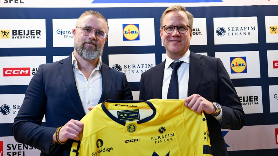 Johan Stark, tidigare Generalsekreterare på Svenska Ishockeyförbundet och Joakim Wiksten, VD på Serafim Finans håller upp den nya matchtröjan